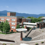 富士山を背景にした静岡県立大学のキャンパス風景。レンガ造りの校舎と円形の中庭が特徴的